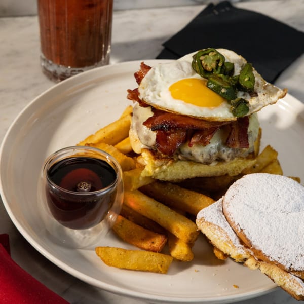 Uncommon Grill's burger with bacon, fried egg, jalapeños, fries, syrup, and powdered sugar pancakes.