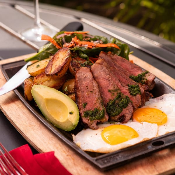 Uncommon Grill's New American steak and eggs with avocado, potatoes, and spinach salad.