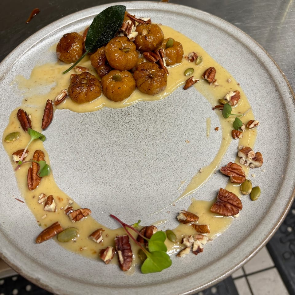 Uncommon Grill's pumpkin gnocchi with sage, pecans, and pumpkin seeds in a creamy sauce.