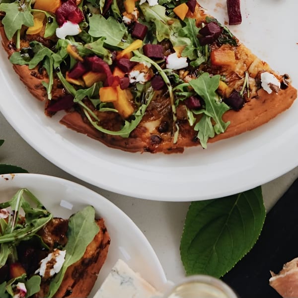 Uncommon Grill's New American pizza, topped with arugula, beets, butternut squash, and goat cheese.